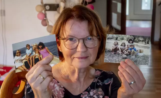 Claudia Huth shows old photos of her children and herself in her house in Egelsbach, Germany, Thursday, Oct. 31, 2024. (AP Photo/Michael Probst)