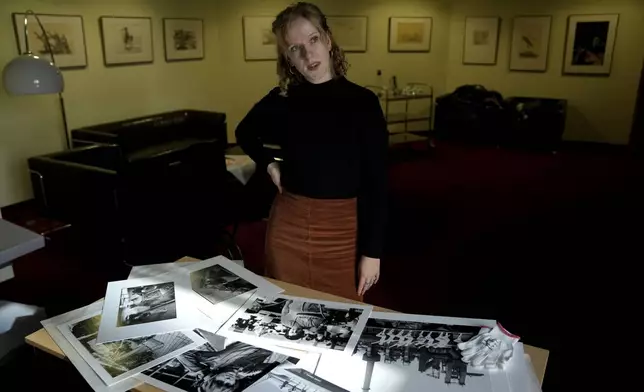 Clara Marz an Organizer of an exhibition about women works on the photos in her office in Berlin, Germany, Thursday, Oct. 17, 2024. (AP Photo/Ebrahim Noroozi)