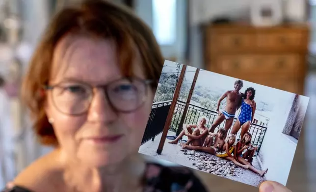 Claudia Huth shows an old photo of her family and herself in her house in Egelsbach, Germany, Thursday, Oct. 31, 2024. (AP Photo/Michael Probst)