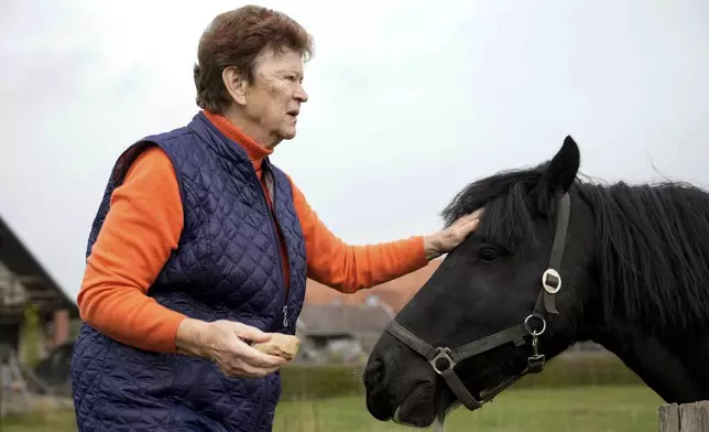 Solveig Leo, 81, former head of a large state-owned farm feeds her horse after the interview with the Associated Press in the northeastern village of Banzkow, Germany, Monday, Oct. 28, 2024. (AP Photo/Ebrahim Noroozi)