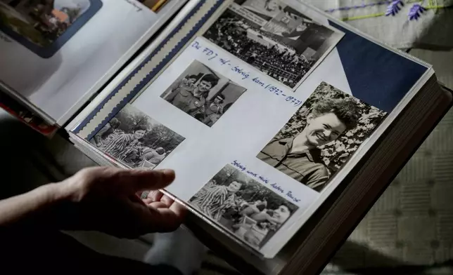 Solveig Leo, 81, former head of a large state-owned farm looks at her old photos album during her interview with the Associated Press in the northeastern village of Banzkow, Germany, Monday, Oct. 28, 2024. (AP Photo/Ebrahim Noroozi)