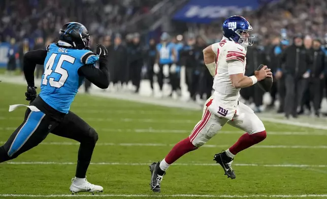 New York Giants quarterback Daniel Jones (8) scores against the Carolina Panthers during the second half of an NFL football game, Sunday, Nov. 10, 2024, in Munich, Germany. (AP Photo/Matthias Schrader)