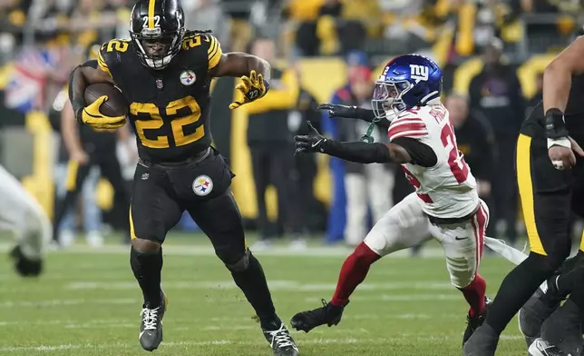 Pittsburgh Steelers running back Najee Harris, left, carries past New York Giants cornerback Dru Phillips during the first half of an NFL football game Monday, Oct. 28, 2024, in Pittsburgh. (AP Photo/Matt Freed)