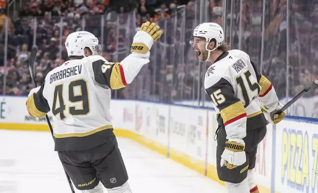 Vegas Golden Knights' Ivan Barbashev (49) and Noah Hanifin (15) celebrate a goal against the Edmonton Oilers during the third period of an NHL hockey game Wednesday, Nov. 6, 2024 in Edmonton, Alberta. (Jason Franson/The Canadian Press via AP)