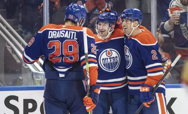 Edmonton Oilers' Leon Draisaitl (29), Zach Hyman (18) and Evan Bouchard (2) celebrate a goal against the Vegas Golden Knights during the second period of an NHL hockey game Wednesday, Nov. 6, 2024 in Edmonton, Alberta. (Jason Franson/The Canadian Press via AP)