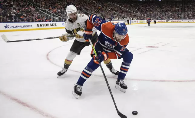 Vegas Golden Knights' Alex Pietrangelo, left, and Edmonton Oilers' Leon Draisaitl (29) battle for the puck during the second period of an NHL hockey game Wednesday, Nov. 6, 2024 in Edmonton, Alberta. (Jason Franson/The Canadian Press via AP)