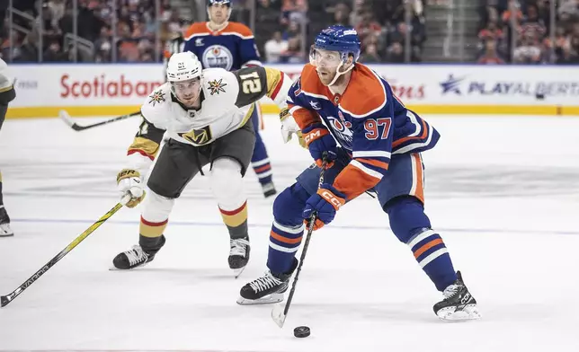 Vegas Golden Knights' Brett Howden (21) chases Edmonton Oilers' Connor McDavid (97) during the second period of an NHL hockey game Wednesday, Nov. 6, 2024 in Edmonton, Alberta. (Jason Franson/The Canadian Press via AP)