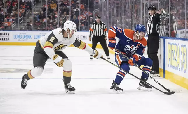 Vegas Golden Knights' Zach Whitecloud (2) tries to get the puck from Edmonton Oilers' Connor McDavid (97) during the second period of an NHL hockey game Wednesday, Nov. 6, 2024 in Edmonton, Alberta. (Jason Franson/The Canadian Press via AP)