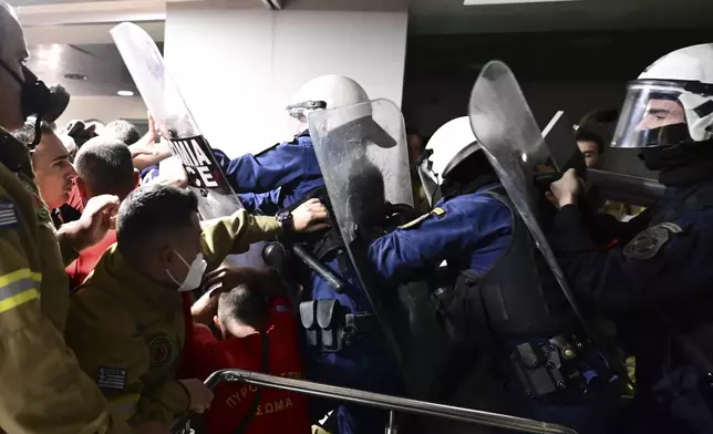 Riot police clash with seasonal firefighters inside Greece's Civil Protection Ministry during a protest to demand permanent positions as their contracts expire following a grueling wildfire season, in Athens, Thursday, Oct. 31, 2024. (Michalis Karayannis/Eurokinissi via AP)