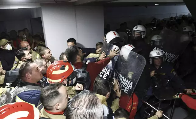 Seasonal firefighters clash with riot police inside Greece's Civil Protection Ministry during a protest to demand permanent positions as their contracts expire following a grueling wildfire season, in Athens, Thursday, Oct. 31, 2024. (John Liakos/InTime News via AP)