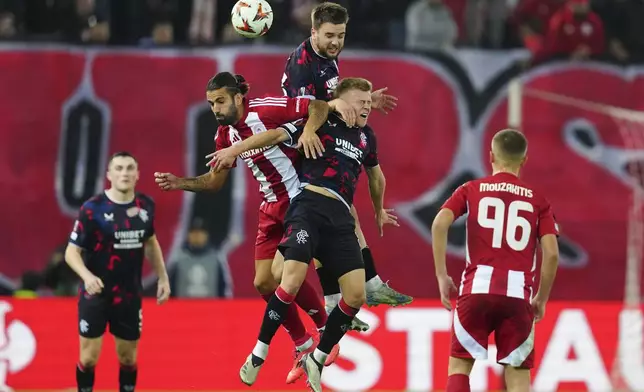 Olympiacos' Sergio Oliveira, left, jumps for the Baal among Rangers' Robin Proepper, centre and Connor Barron, right, during the Europa League opening phase soccer match between Olympiacos and Rangers at the Georgios Karaiskakis stadium at Athens' port of Piraeus, Greece, Thursday, Nov. 7, 2024. (AP Photo/Thanassis Stavrakis)