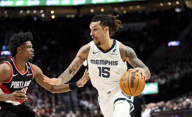 Memphis Grizzlies forward Brandon Clarke, right, drives to the hoop against Portland Trail Blazers guard Scoot Henderson, left, during the second half of an NBA basketball game Sunday, Nov. 10, 2024, in Portland, Ore. (AP Photo/Howard Lao)