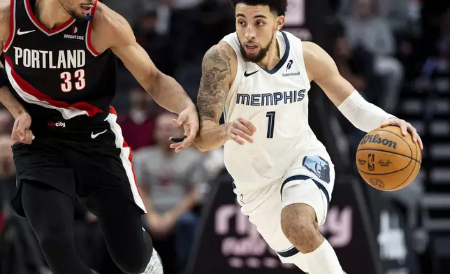 Memphis Grizzlies guard Scotty Pippen Jr., right, dribbles the ball against Portland Trail Blazers forward Toumani Camara, left, during the second half of an NBA basketball game Sunday, Nov. 10, 2024, in Portland, Ore. (AP Photo/Howard Lao)