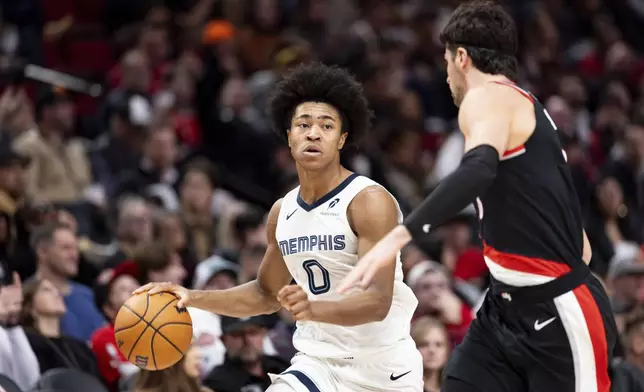 Memphis Grizzlies forward Jaylen Wells, left, dribbles the ball against Portland Trail Blazers forward Deni Avdija, right, during the second half of an NBA basketball game, Sunday, Nov. 10, 2024, in Portland, Ore. (AP Photo/Howard Lao)