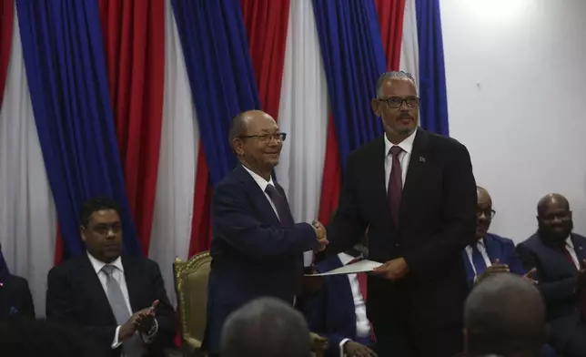 Haiti's new Prime Minister Alix Didier Fils-Aimé, right, shakes hands with Transition Council President Leslie Voltaire during his swearing-in ceremony in Port-au-Prince, Haiti, Monday, Nov. 11, 2024. (AP Photo/Odelyn Joseph)