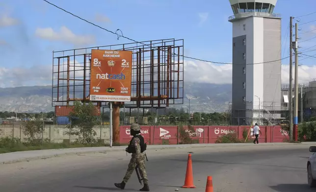 A police officer patrols the entrance of the Toussaint Louverture International Airport, in Port-au-Prince, Haiti, Tuesday, Nov. 12, 2024. (AP Photo/Odelyn Joseph)