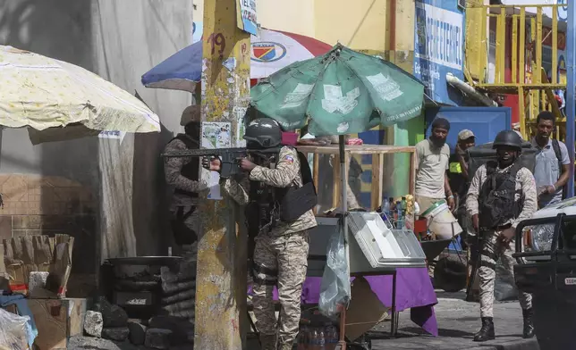 Police officers patrol a street during an exchange of gunfire between gangs and police in Port-au-Prince, Haiti, Monday, Nov. 11, 2024. (AP Photo/Odelyn Joseph)