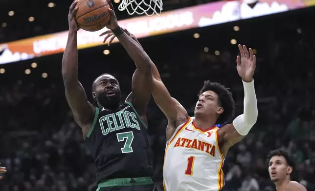 Boston Celtics guard Jaylen Brown (7) drives to the basket against Atlanta Hawks forward Jalen Johnson (1) during the first half of an Emirates NBA Cup basketball game, Tuesday, Nov. 12, 2024, in Boston. (AP Photo/Charles Krupa)