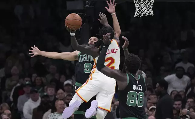 Boston Celtics guard Derrick White (9) tries to stop Atlanta Hawks guard Keaton Wallace (2) on a drive to the basket during the first half of an Emirates NBA Cup basketball game, Tuesday, Nov. 12, 2024, in Boston. (AP Photo/Charles Krupa)