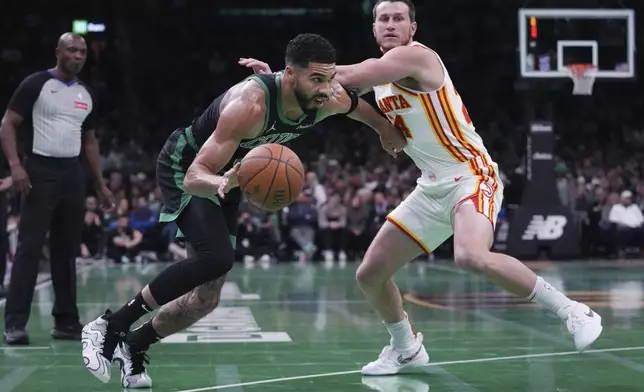 Boston Celtics forward Jayson Tatum, center left, drives to the basket against Atlanta Hawks guard Garrison Mathews (24) during the first half of an Emirates NBA Cup basketball game, Tuesday, Nov. 12, 2024, in Boston. (AP Photo/Charles Krupa)