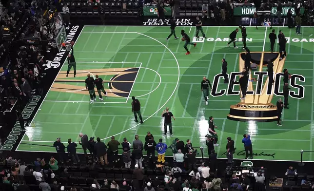 The Boston Celtics practice on a alternate floor, replacing the historic parquet court as part of the Emirates NBA Cup, prior to an basketball game against the Atlanta Hawks, Tuesday, Nov. 12, 2024, in Boston. (AP Photo/Charles Krupa)