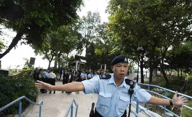 Police officers cordon off an area where a Southeast Asian woman's body was found Monday at a waterfall inside a park in Hong Kong, Wednesday, Oct. 30, 2024. (AP Photo/Bertha Wang)