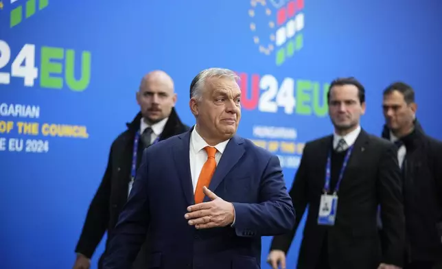 Hungary's Prime Minister Viktor Orban, second left, speaks with the media at arrivals for an EU Summit at the Puskas Arena in Budapest, Hungary, Friday, Nov. 8, 2024. (AP Photo/Petr David Josek)