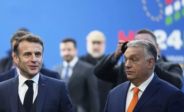 French President Emmanuel Macron, left, speaks with Hungary's Prime Minister Viktor Orban as he arrives for an EU Summit at the Puskas Arena in Budapest, Hungary, Friday, Nov. 8, 2024. (AP Photo/Petr David Josek)