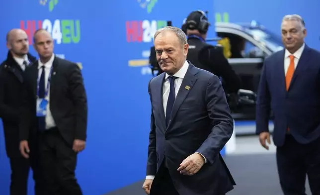 Poland's Prime Minister Donald Tusk, center, arrives for an EU Summit at the Puskas Arena in Budapest, Hungary, Friday, Nov. 8, 2024. (AP Photo/Petr David Josek)