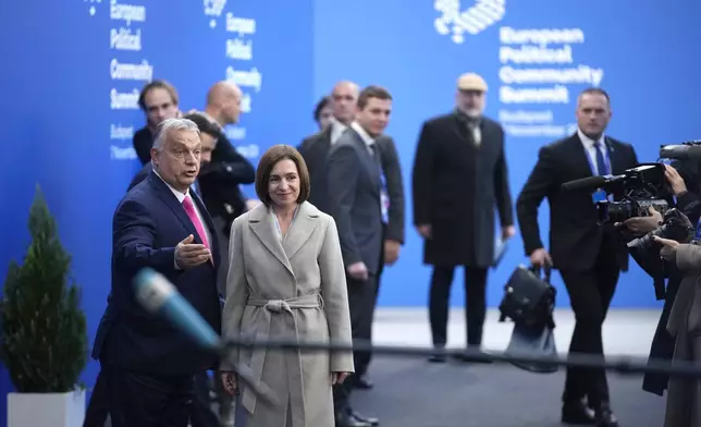 Hungary's Prime Minister Viktor Orban, left, welcomes Moldova's President Maia Sandu during arrivals for the European Political Community (EPC) Summit at the Puskas Arena in Budapest, Hungary, Thursday, Nov. 7, 2024. (AP Photo/Petr Josek)