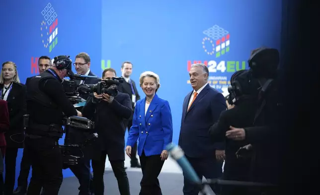 European Commission President Ursula von der Leyen, center, speaks with Hungary's Prime Minister Viktor Orban, right, as she arrives for an EU Summit at the Puskas Arena in Budapest, Hungary, Friday, Nov. 8, 2024. (AP Photo/Petr David Josek)