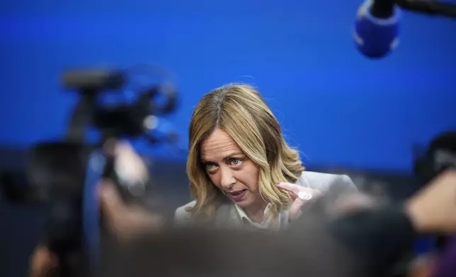 Italy's Prime Minister Giorgia Meloni speaks with the media as she arrives for an EU Summit at the Puskas Arena in Budapest, Hungary, Friday, Nov. 8, 2024. (AP Photo/Petr David Josek)