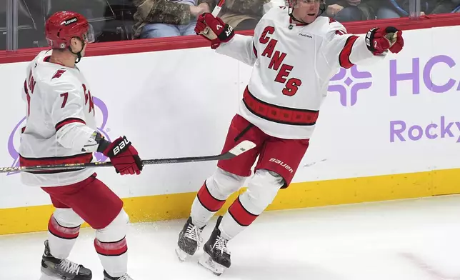 Carolina Hurricanes defenseman Dmitry Orlov, left, congratulates center Jack Drury after his goal against the Colorado Avalanche in the first period of an NHL hockey game Saturday, Nov. 9, 2024, in Denver. (AP Photo/David Zalubowski)