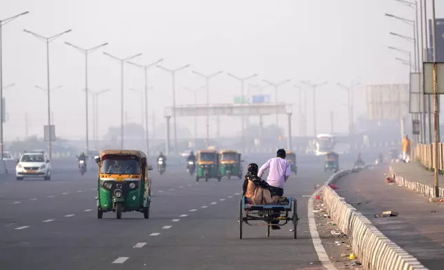 People commute in the early morning smog the day after the Hindu festival Diwali, in New Delhi, India, Friday, Nov. 1, 2024. (AP Photo/Manish Swarup)