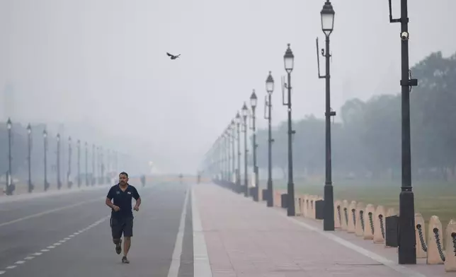 A man jogs in the early morning smog, the day after the Hindu festival Diwali, in New Delhi, India, Friday, Nov. 1, 2024. (AP Photo/Manish Swarup)