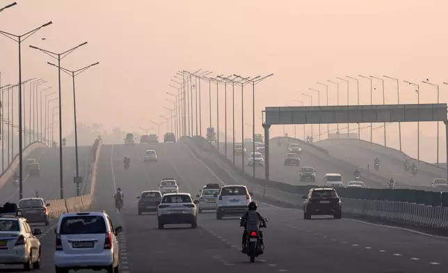 People commute in the early morning smog, the day after the Hindu festival Diwali, in New Delhi, India, Friday, Nov. 1, 2024. (AP Photo/Manish Swarup)