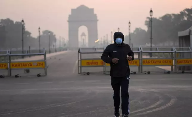 A man wears a face mask as he jogs in the early morning smog, the day after the Hindu festival Diwali, in New Delhi, India, Friday, Nov. 1, 2024. (AP Photo/Manish Swarup)