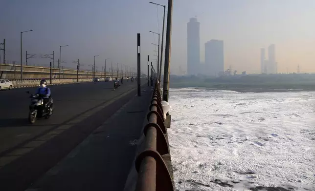 A commuter rides in the early morning smog on a bridge over Yamuna river covered in pollutants the day after the Hindu festival Diwali, in New Delhi, India, Friday, Nov. 1, 2024. (AP Photo/Manish Swarup)