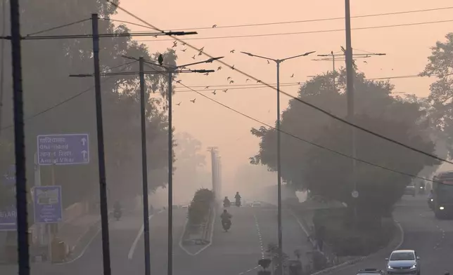 People commute in the early morning smog the day after the Hindu festival Diwali, in New Delhi, India, Friday, Nov. 1, 2024. (AP Photo/Manish Swarup)