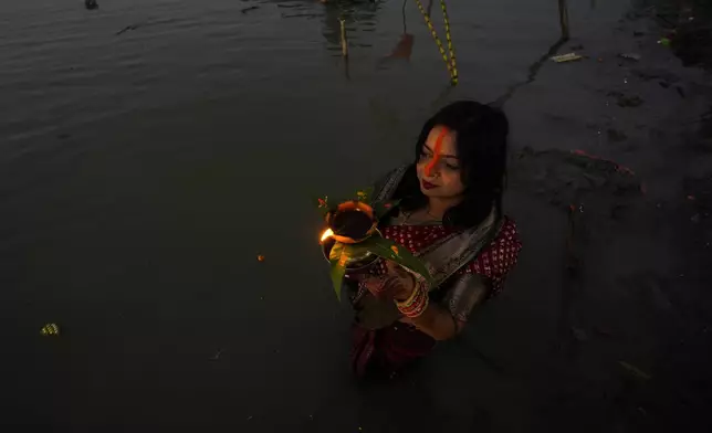 A Hindu devotee offers prayers at the river Brahmaputra during Chhath Puja festival in Guwahati, northeastern Assam state, India, Thursday, Nov. 7, 2024. (AP Photo/Anupam Nath)