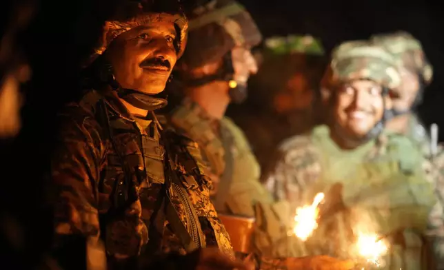 Indian army soldiers light firecrackers to celebrate Diwali, near the Line of Control that divides Kashmir region between India and Pakistan, in Akhnoor sector, Jammu and Kashmir, India, Monday, Oct. 28, 2024.(AP Photo/Channi Anand)