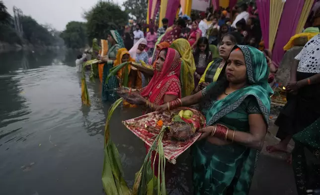 Hindu devotees perform rituals at sunset on the Ranbir canal during Chhath Puja festival in Jammu, India, Thursday, Nov. 7, 2024. (AP Photo/Channi Anand)