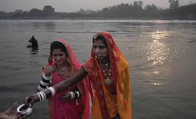 Devotees perform rituals on the banks of the river Yamuna as they offer prayer to the sun god during Chhath festival in Noida, near New Delhi, India, Thursday, Nov. 7, 2024. (AP Photo/Manish Swarup)