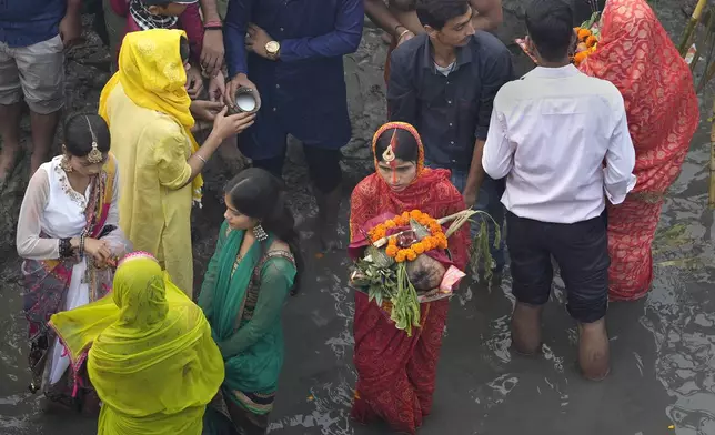 A devotee performs rituals on the banks of the river Yamuna during Chhath festival in Noida, near New Delhi, India, Friday, Nov. 8, 2024. (AP Photo/Manish Swarup)