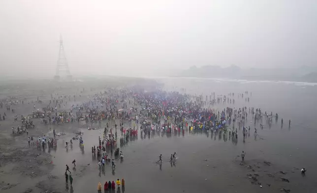 Devotees pray as they wait for the sun to rise on the banks of the river Yamuna during Chhath festival in Noida, near New Delhi, India, Friday, Nov. 8, 2024. (AP Photo/Manish Swarup)