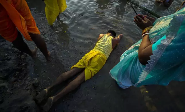 A Hindu devotee prostrates to the river Brahmaputra during Chhath festival in Guwahati, in the northeastern Indian state of Assam, India, Thursday, Nov. 7, 2024. (AP Photo/Anupam Nath)