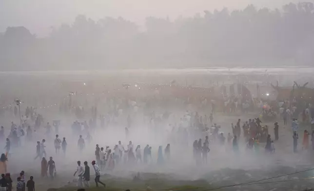 Devotees arrive on the banks of the river Yamuna to offer prayers as smog and dust envelops the skyline during Chhath festival in Noida, near New Delhi, India, Thursday, Nov. 7, 2024. (AP Photo/Manish Swarup)