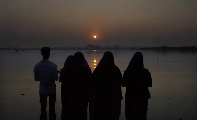 Hindu devotees pray to the sun god standing in knee deep waters in the Hussain Sagar Lake during the Chhath festival in Hyderabad, India, Thursday, Nov. 7, 2024. (AP Photo/Mahesh Kumar A.)