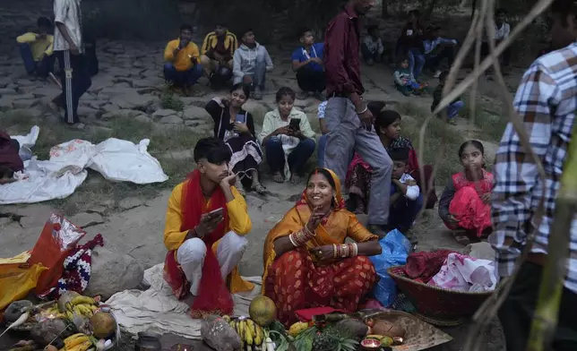 A couple sits with offerings on the banks of the river Yamuna during Chhath festival in Noida, near New Delhi, India, Friday, Nov. 8, 2024. (AP Photo/Manish Swarup)