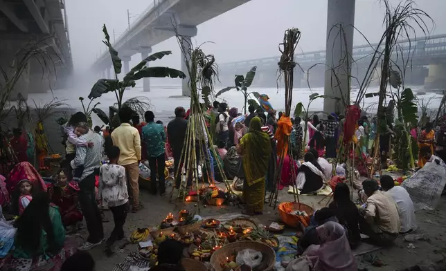 Devotees pray on the banks of the river Yamuna as toxic foam flows during Chhath festival in Noida, near New Delhi, India, Friday, Nov. 8, 2024. (AP Photo/Manish Swarup)